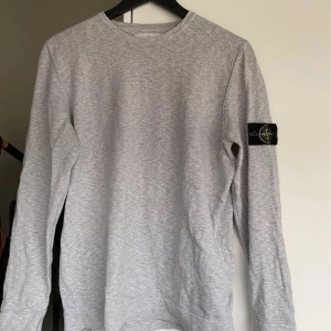 Stone island crewneck - Grå stone island crewneck storlek L men skulle passa M också, bra skick och äkta (Qr finns) kan bytta och priset kan diskuteras vid smidig affär