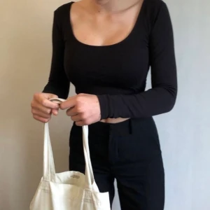 Svart tight tröja - Svart och tight croptop med djup urringning och långa ärmar. Tröjan är från BikBok och säljs pga att den är för liten för mig. Den är stl S men skulle säga att den också passar XS. Köpare står för frakt och skriv gärna vid eventuella frågor😊