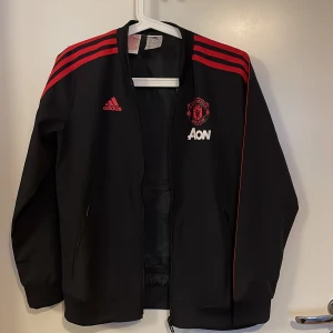 Manchester United zip  - Manchester United, En tunn zip-jacka.  Nästan helt oanvänd.