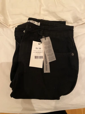 Svarta håliga jeans  - Svarta jeans i kortare modell med 3 ordentliga slita på benen