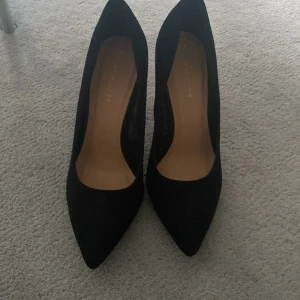 Oanvända höga pumps - Oanvända höga pumps. Svart mocka imitation. 