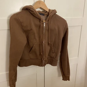 Brun Fliströja - Säljer denna superfina croppade, bruna fliströja från brandy Melville. Super fint skick! Storlek XS-S. Skriv i dm för fler bilder🥰