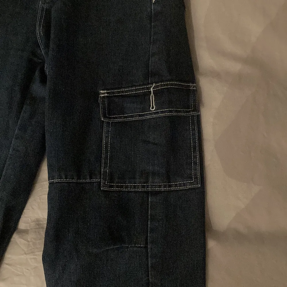 Ett par jeans med balla fickor och kontrastsömmar . Jeans & Byxor.