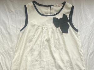 Snygg fest topp - Jätte söt blus fest topp med rosett. Köpt på H&M för flera år sedan. Kommer inte till användning längre så säljer den. Barnstorlek (152) Men passar S och mindre! Lite genomskinlig. Så bäst om man har något under om man vill! Frakt ingår i priset. ❤️🥰