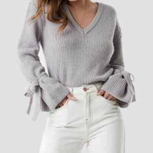 Linn Ahlborg X NAKD beige/rosa - Mysig stickad tröja med söta rosettdetaljer vid ärmarna från Linn Ahlborgs kollektion med NAKD. Tröjan är endast använd 2 gånger och är i väldigt fint skick💓 Den är i en fin beige/rosa färg, perfekt till våren eller över en klänning på sommarkvällar. XS enligt tillverkaren men passar även S!