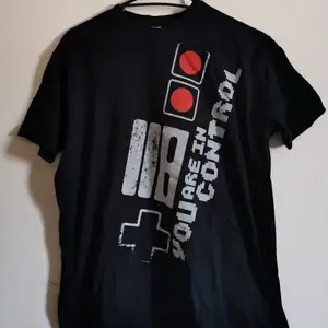 Säljer denna t-shirten jag köpte för flera år sedan på GameStop. Använt den en massa gånger men den är fortfarande i bra skick! ☁️ Originalpris: 199kr. ☁️ Det är meningen att trycket ska se lite 
