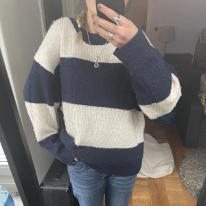 Stickad tröja  - Jätte skön och mysig stickad tröja i blått och vitt randigt mönster. Är i storlek XL men passar fler storlekar beroende på hur man vill att den ska sitta!
