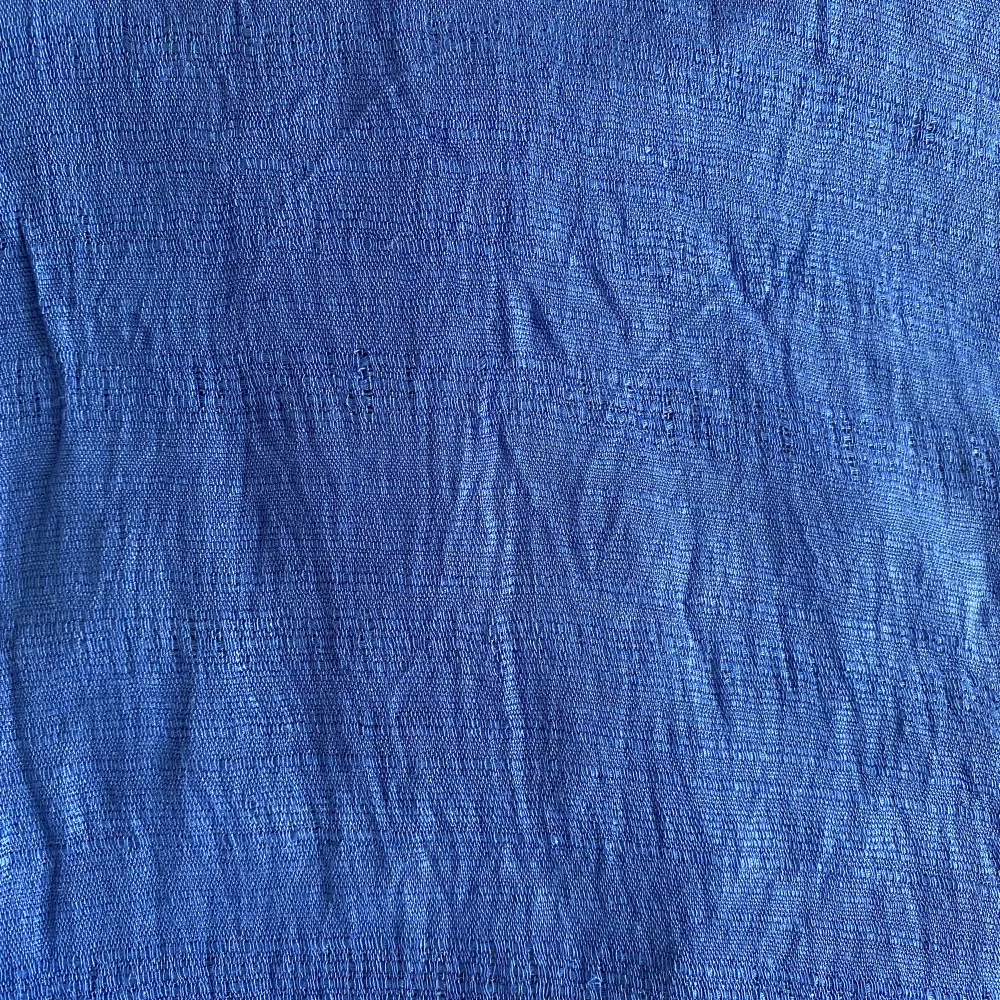 En klarblå Sidensjal med fransar.  Den är köpt på en marknad i Thailand för några år sedan. Men det finns inte någon material-lapp kvar så jag kan inte garantera att det är 100% Siden.  Materialet är lätt och fint.  Det finns några revor (sista bilden).. Övrigt.