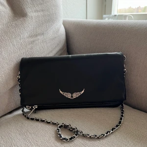 Zadig väska rock - Orderbekräftelse finns från Zadig&Voltaires hemsida och skickas via meddelande till den som önskar att se detta. Inköpt för 320€ vilket motsvarar 3600kr på deras hemsida. Använd extremt sparsamt så skicket är som ny