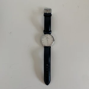 Klocka Daniel.W - Klocka från Daniel Wellington med silvriga detaljer. Använd men i fint skick. Batteri får köpas nytt. Extra rem medföljer (se bild 3). #danielwellington