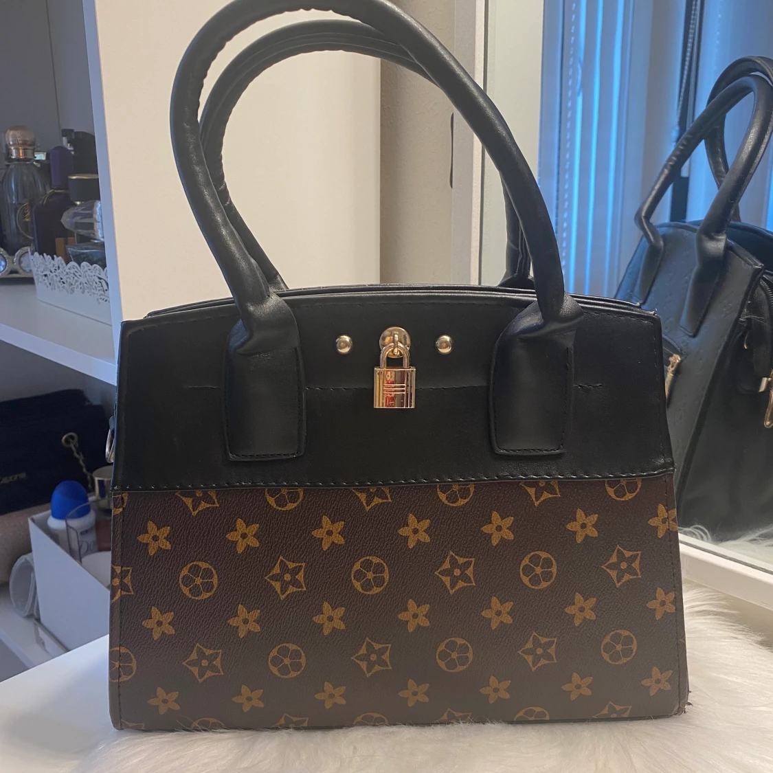 Svart brun hand mellan stor handväska