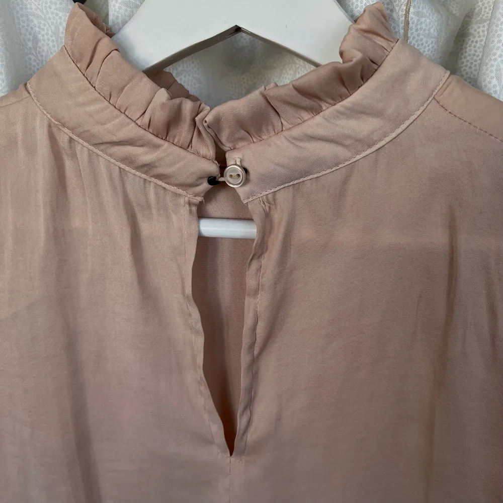 Rosé färgad blus i silke, säkerhetsnålslösning vid knappen i nacken. Blusar.