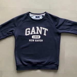 Gant sweatshirt - Stilren Gant sweatshirt.✨  Hittar inte denna tröja på Gant’s hemsida men liknande plaggs nypris ligger på 800 kr. Trycket är lite slitet men inget märkvärdigt. Storlek S men sitter nog bättre på någon med XS!
