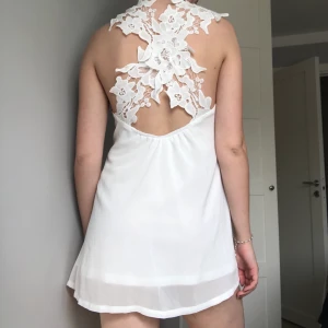 Klänning DMRETRO  - Kort modell med ett kryss av spets på ryggen. Mer bilder kan fås vid intresse. 🌸