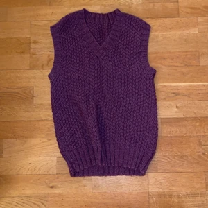 Fin stickad lila väst - En fin stickad lila väst. Mått mellan armhålorna är43 cm. längd är ca 65 cm