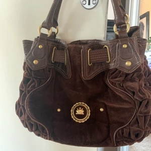  Juicy couture  - En brun juicy couture väska i sammet, guldiga detaljer med röt på insidan  är jött esmygg men kommer tyvärr inte till användning , skriv för mer bilder eller frågor ❤️ pris kan diskuteras 