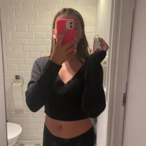 Stickadtröja - En svart stickad tröja som är cropad och lite urringad 