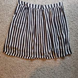 Jag säljer en kjol ifrån minimum i storlek 38. Den är randig i färgerna svart och vit. Den har två fickor på sidorna.