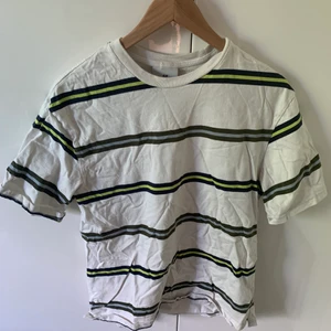 En randig t-shirt - En randig vit t-shirt med gröna och blå ränder. 