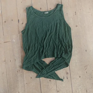 Grön flowy topp - Färgen är väldigt skogsgrön, tänk barren på en gran. Går att knyta där bak. Skönt stretchigt material. 