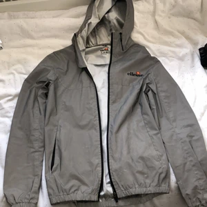 Ellesse reflexjacka - Riktigt snygg Ellesse reflexjacka. Den är i bra skick men lite använd, förrutom skadan som syns i bilden har den inga andra problem. Priset kan diskuteras vid snabb affär. Storlek xs men passar lite större storlekar också.