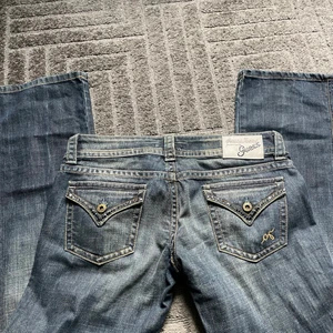 Guess lågmidjade bootcut jeans -  Superfin och unik jeans modell från guess  i superfin blå vintage färg, Säljer då de tyvärr var för långa på mig som är runt 160!:( De passar längd 32. Innerbenslängden är ca 86cm och midjemåttet= ca 79-80cm 