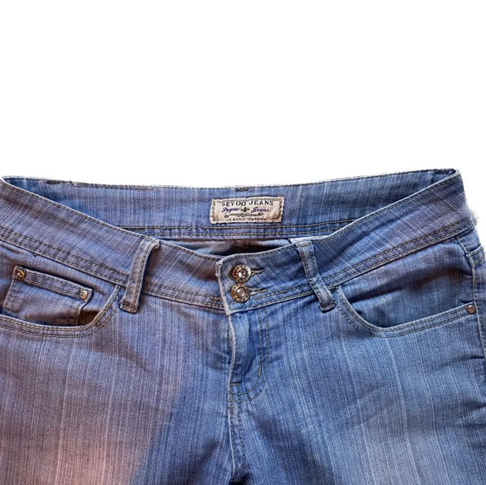 Skitsnygga 90s 2000s bootcut jeans från ’Seyoo Jeans’. Supersöta kristall detaljer på knapparna och där bak. Tyget är supersnyggt och nästan lite randigt.  Jag kan mötas upp eller frakta. Storlek: 40. Midjemått: 85cm. Innerbenslängd: 80cm. . Jeans & Byxor.