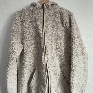 Fluffig kofta - Skönaste och mysigaste koftan i ”ull” Med luva och en liten detalj vid fickan. Andvänds inte längre 