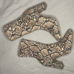 Boots mes klack  - Ormskinnsmönstrade stövlar i tyg med klack