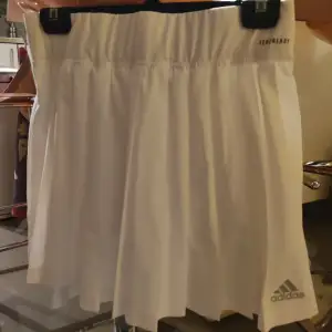 En snygg Adidas kjol som påminner om en tenniskjol. Helt NY och oanvänd. 