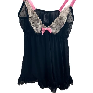 Svart linne - Så fint svart linne med genomskinligt svart tyg, vita spetsdrtaljer och rosa band som går att knyta. Aldrig använd då det inte är min stil. Kan mötas upp i Stockholm eller frakta då köparen står för frakten💕