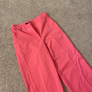Rosa kostymbyxor  - Ett par rosa kostymbyxor i stolek 36 ifrån Bik Bok. Jag har använt de några gånger men det ser ut som nya. Jag säljer de pågrund av att de har blivit förkorta för mig. Passar någon som är kortare än 165 cm. Nypris:399kr. Frakt ingår inte!!