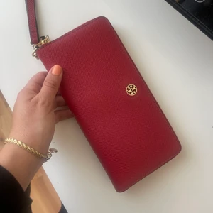Tory burch plånbok  - Plånbok från tory burch. Passar perfekt till pass också. Stor å rymlig med många fack. Så gott som ny använt en gång bara.  Köptes för över 2000kr. Spårbar frakt 66kr 