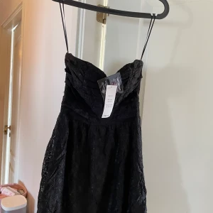Svart spetsklänning - nyskick lapp kvar - Säljer nu en fin svart spetsklänning, bara axlar. Färg svart, Stlk 36.