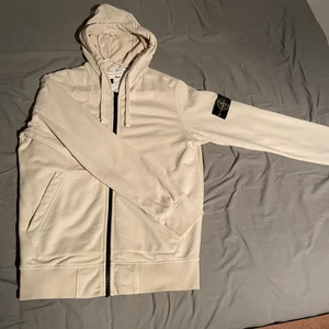 Stone Island Zip Hoodie - Fint skick, nypris: 2999 SEK Bjuder frakt vid snabb affär. Färgen är Cream white. Authentic med QR kod samt kvitto om önskas!