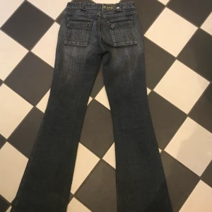 Y2k lågmidjade jeans - Snygga lågmidjade jeans med coola detaljer. Bra skick men något slitet längst ner på byxan (be om bild). Frakt betalar kund utöver priset