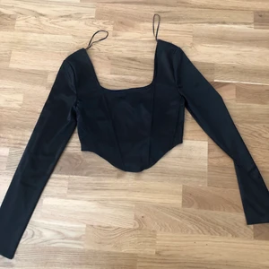 Långärmad topp - Korsettliknande långärmad topp från H&M. Aldrig använd, prislapp kvar ! Andra bilden är samma topp fast lånad av en vän. Möts gärna upp eller skickas med brev :) 