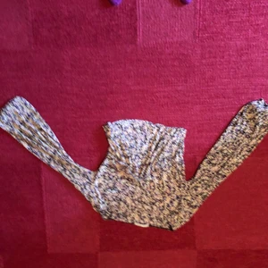 Topp - En v-ringad magtröja med tunt material och blommigt mönster.