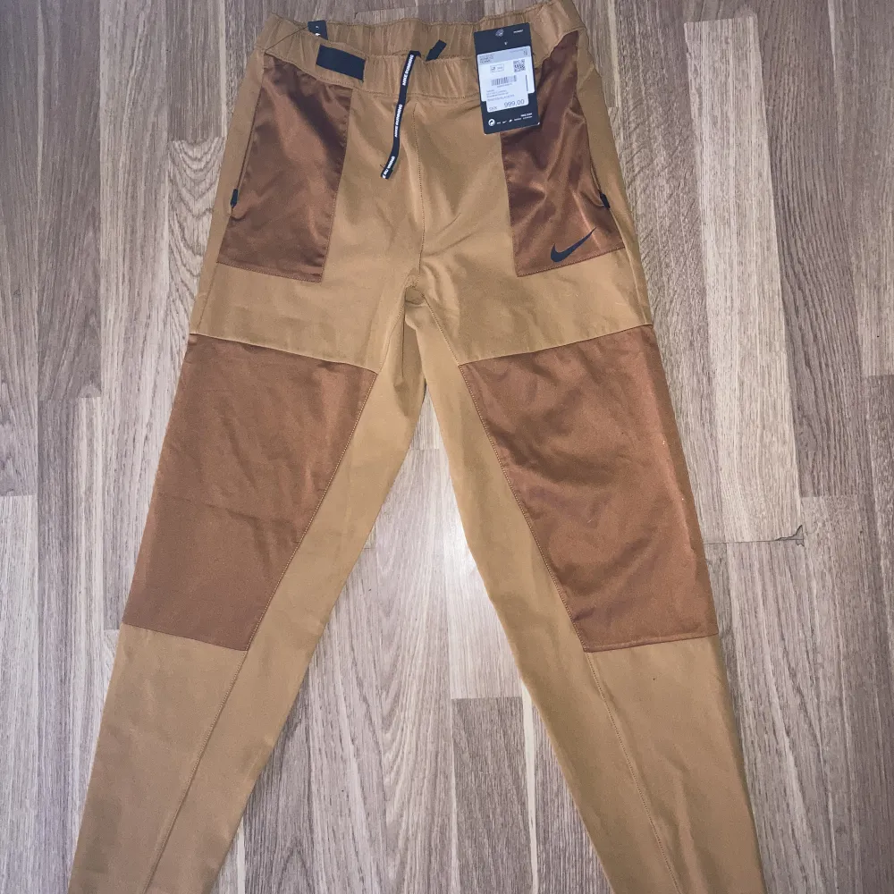 Helt nya byxor Nike strl xs  Guld/gul färg.  Nypris 999:- . Jeans & Byxor.