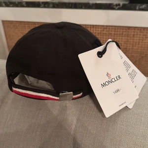 Moncler - Säljer nu min näst intill oanvända Moncler keps. Den är inköpt på NK för 1500kr. Skick 9/10, Mitt pris 999kr