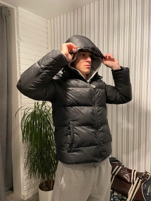 Gant Puffer Jacket - Hej! Jag säljer min svarta Gant puffer jacket. Den har ett litet hål vid höger armbåge som syns i sista bilden men utöver det är den i väldigt fint skick! Storlek: 170cm men sitter som S. (jag är 174cm och den sitter utmärkt). Kan posta och mötas i sthlm!