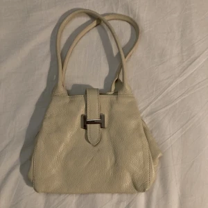 Vit handväska - Säljer denna benvita väskan köpt på loppis pga att den inte kommer till användning. Bara att fråga om fler bilder/bilder på insidan etc. 