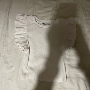 Volangtopp från Zara storlek Small - Volangtopp från Zara och har använts 2 gånger. Är i väldigt bra skick.👍Storlek S ganska liten i storleken (enligt mig). Jag har i vanliga fall XS. Säljer för att jag inte använder den längre.💞
