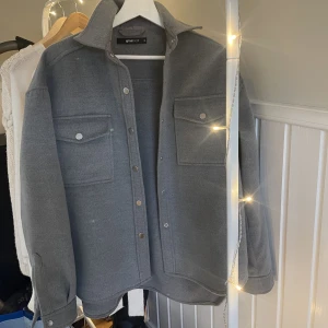 Jacka  - Grå Jacka från Gina tricot storlek 34. , längre i bak. Knappt använd 