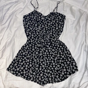 Svart jumpsuit - Svart jumpsuit med vita blommor på från FBsister. Storlek S. Använd en gång. Fråga gärna om bild på hur den ser ut på om ni vill.