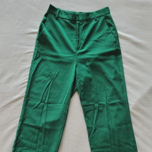 Ärtgröna vida byxor från Lindex - Ärtgröna vida byxor från Lindex. Fickor i sidorna och fejkfickor bak. Resår bak. Bälteshällor.  68% polyester 29% viskos 3% elastan  Toppenskick! Säljer pga att de inte passar mig längre 😊