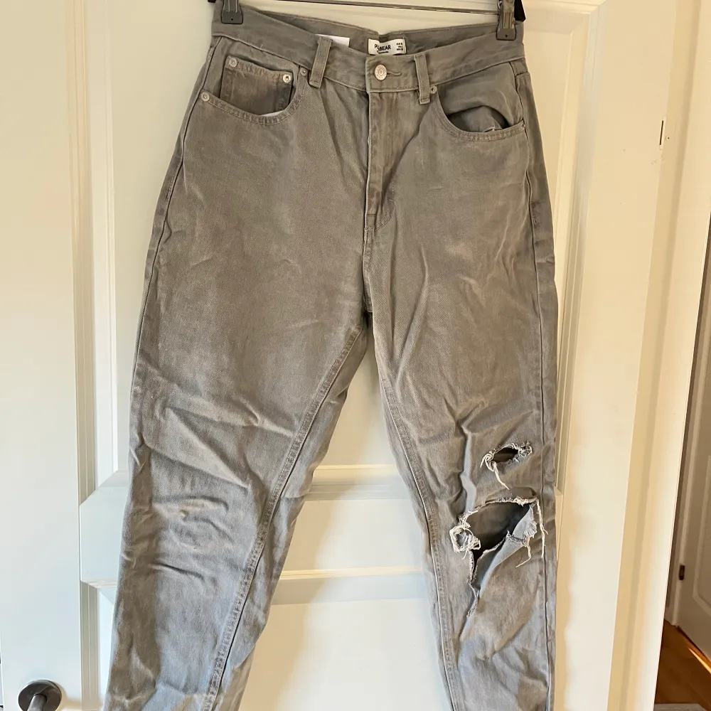 Säljer nu ett par gråa min jeans med hål på ena knät. De kommer från pull and bear och är endast använda max 3 gånger🥰OBS liten i storleken och du står för frakten ca 50 kr☺️. Jeans & Byxor.
