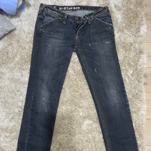 Lågmidjade jeans - Snygga straight jeans med låg midja från g-star. Mörkgrå färg med snygga detaljer bak. Skriv för frågor, har tyvärr inga bilder på då de är försmå för mig. Frakt tillkommer