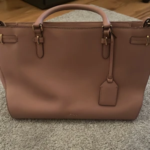 Ralph lauren väska  - Ralph lauren väska i jätte fint skick. Band som kommer med gör så att det funkar som axelväska. 