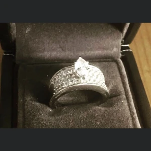 Vacker ring med livstids garanti - Silver ring med garanti hela livet med andra ord så är den så pläterad med rodium att den håller sig fin hela tiden och jag kan intyga detta. Den ser ut som dagen jag köpte den. Kostade 1099:- vet ej vad det är för stenar inköpt på adelstedt. Strl 17. 